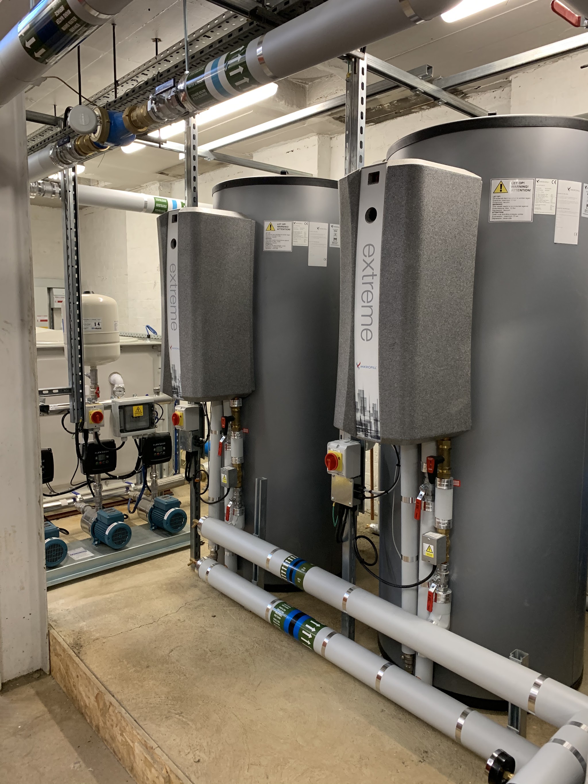 A plant room fitted by Sterling: two large hot water cylinders, booster pumps and insulated pipework