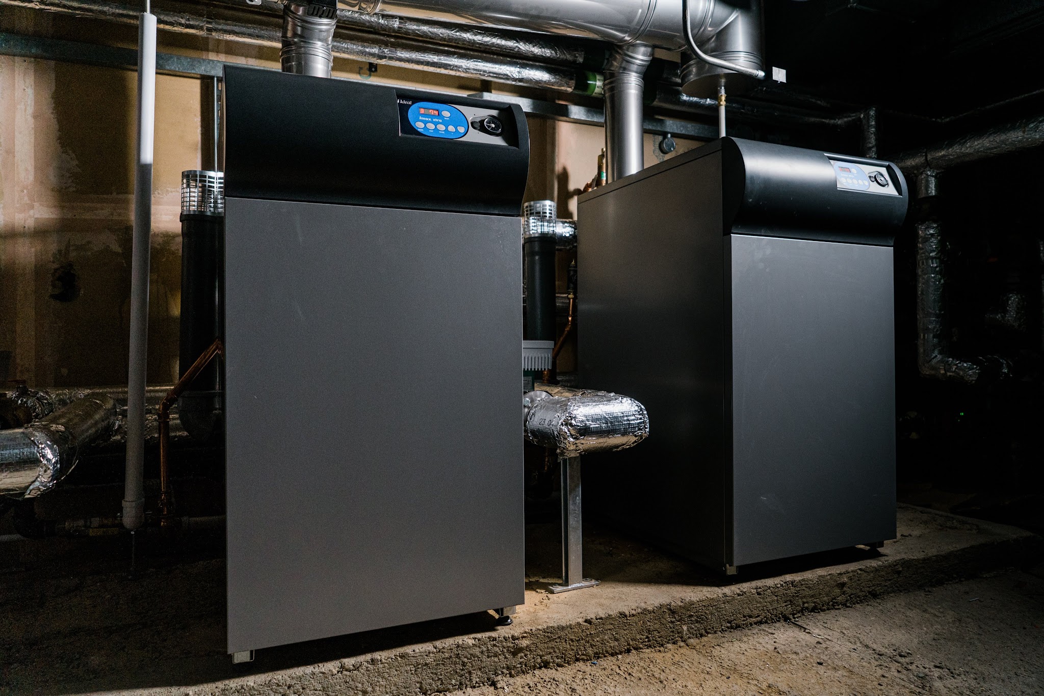 Two floor-standing commercial boilers installed side by side in a plant room